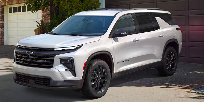Front three-quarter view of a white SUV parked in a residential driveway