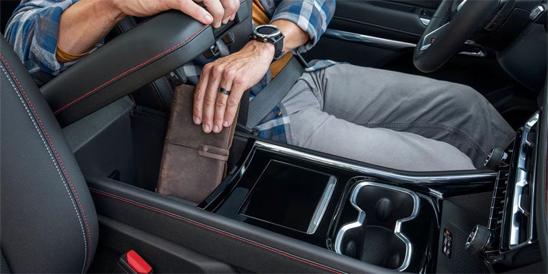 Close-up view of a vehicle’s center console with the armrest storage compartment open