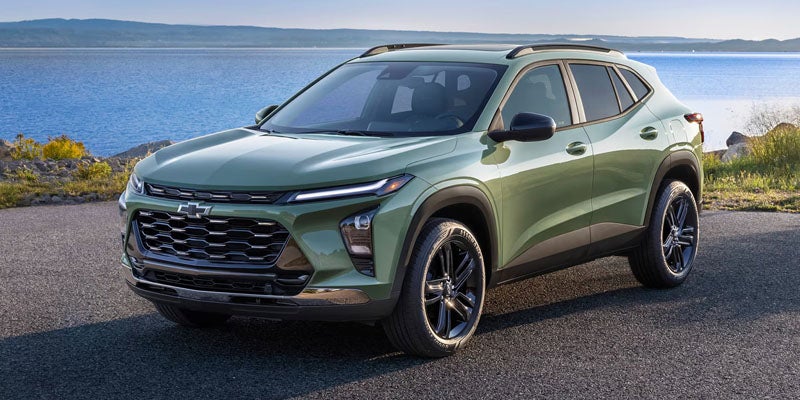 Light green SUV parked beside a waterfront road, shown from the front three-quarter angle